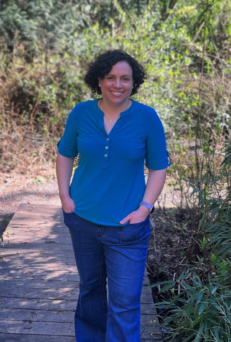 Helena walking in the woods over a wooden bridge